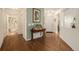 Inviting foyer with hardwood floors, light green accent wall, and a view of the front door and bathroom at 7683 S Biloxi Way, Aurora, CO 80016