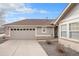 View of the home's garage, driveway, and a peek at the covered entryway on a sunny day at 7683 S Biloxi Way, Aurora, CO 80016