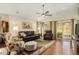 Bright living room featuring hardwood floors, comfortable seating, a ceiling fan, and sliding glass doors at 7683 S Biloxi Way, Aurora, CO 80016