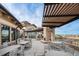 Spacious outdoor patio with stone fireplace, pergola, and scenic views for relaxing and entertaining at 7683 S Biloxi Way, Aurora, CO 80016