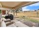 Covered patio with comfortable seating and a grill overlooking a lush green lawn at 7683 S Biloxi Way, Aurora, CO 80016