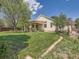 Large backyard with a well-maintained lawn and mature trees at 1649 Iris St, Broomfield, CO 80020