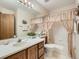 Traditional bathroom featuring a vanity with a large mirror and a tub with curtain at 1649 Iris St, Broomfield, CO 80020
