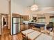 Open-concept kitchen with stainless steel appliances, wood cabinetry, and eat in kitchen and dining space at 1649 Iris St, Broomfield, CO 80020
