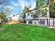 Large backyard features plush green grass, a partial fence, and mature trees at 19897 E Brunswick Dr, Aurora, CO 80013