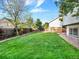 Beautiful fenced backyard has lush green grass, trees, and plenty of space at 19897 E Brunswick Dr, Aurora, CO 80013