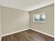 Bright bedroom features warm paint, wood-look flooring, and a sun-filled window at 19897 E Brunswick Dr, Aurora, CO 80013