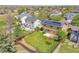 Aerial view of a home with solar panels, fenced backyard with large lawn, and mature trees at 11963 Dahlia Dr, Thornton, CO 80233