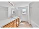 Bathroom featuring a wide mirror, single sink vanity with wood cabinets, and tub and shower at 11963 Dahlia Dr, Thornton, CO 80233
