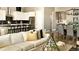 Open concept living room with white sofa, modern furniture, and adjacent kitchen and dining area at 3867 Freestone Pt, Castle Rock, CO 80108