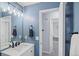 Stylish bathroom with blue walls, modern vanity, and a view into the connected bedroom, enhancing natural light at 3228 W Girard Ave # C, Englewood, CO 80110