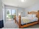 Comfortable bedroom with a wood-frame bed, large windows, and access to a private balcony overlooking greenery at 3228 W Girard Ave # C, Englewood, CO 80110