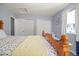 Bright bedroom with a wood-frame bed, featuring ample closet space and natural light from the large windows at 3228 W Girard Ave # C, Englewood, CO 80110