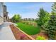 A plush backyard is surrounded by a wood fence and features landscaping and a trampoline in the yard at 8179 S Kellerman Cir, Aurora, CO 80016