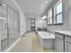 Bright bathroom featuring a walk-in shower, soaking tub, double vanity, and modern fixtures at 8179 S Kellerman Cir, Aurora, CO 80016