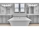 Bright bathroom featuring a luxurious soaking tub, double vanity, and modern fixtures at 8179 S Kellerman Cir, Aurora, CO 80016