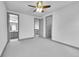 Spacious bedroom with gray carpet, trim, ceiling fan, and access to a bathroom at 8179 S Kellerman Cir, Aurora, CO 80016
