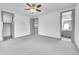 Spacious bedroom with gray carpet, trim, ceiling fan, and access to a bathroom at 8179 S Kellerman Cir, Aurora, CO 80016
