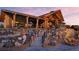 A clubhouse features wood columns and beams, a rock facade, and outdoor seating on multiple levels at 8179 S Kellerman Cir, Aurora, CO 80016