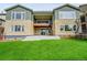 The back of the house features a covered patio, a yard, and a gray and stone facade at 8179 S Kellerman Cir, Aurora, CO 80016