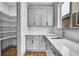Bright kitchen featuring light-gray cabinetry, quartz countertop, and large walk-in pantry at 8179 S Kellerman Cir, Aurora, CO 80016