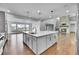 Open kitchen with island, stainless steel appliances, and view to the living room and fireplace at 8179 S Kellerman Cir, Aurora, CO 80016