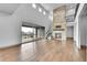 Open living room with stone fireplace, hardwood floors, and patio doors, leading to outdoor deck at 8179 S Kellerman Cir, Aurora, CO 80016