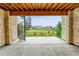 A covered outdoor patio area features stone walls, a concrete floor, and a spiral staircase to the yard at 8179 S Kellerman Cir, Aurora, CO 80016
