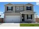 Charming two-story home with a front-facing two car garage, green lawn, and black window shutters at 2204 Alyssa St, Fort Lupton, CO 80621