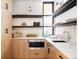 Modern butler's pantry with marble countertops, light wood cabinets, and open shelving at 580 S Franklin St, Denver, CO 80209
