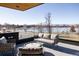 Scenic rooftop terrace with stylish seating and a cozy fire pit overlooking a frozen lake and winter landscape at 580 S Franklin St, Denver, CO 80209