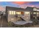 Exterior photo of the back of the home with a deck, patio, stone facade and landscaped yard at 8751 S Wenatchee Ct, Aurora, CO 80016