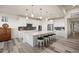 Bright, modern kitchen with stainless steel appliances, a large island with seating and stylish pendant lighting at 8751 S Wenatchee Ct, Aurora, CO 80016