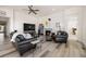 Inviting living room featuring a cozy fireplace, comfortable leather seating, and a large television at 8751 S Wenatchee Ct, Aurora, CO 80016