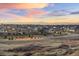 A picturesque view of a suburban neighborhood with houses, landscaping, and open space against a colorful sky at 8751 S Wenatchee Ct, Aurora, CO 80016