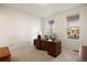 Well-lit home office with a large desk, neutral walls, carpet and natural light from two windows at 8751 S Wenatchee Ct, Aurora, CO 80016
