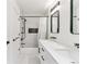 Well-lit bathroom with white marble floors, modern fixtures, and a shower-tub combo at 2280 W 42Nd Ave, Denver, CO 80211