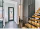Modern entryway with floating stairs and dark hexagonal tile flooring at 2280 W 42Nd Ave, Denver, CO 80211
