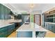 Spacious kitchen with dark blue cabinets, marble countertops, stainless steel appliances, and a large island at 2280 W 42Nd Ave, Denver, CO 80211