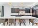 Chic kitchen featuring a large island with seating, sleek dark cabinetry, and modern lighting fixtures at 2280 W 42Nd Ave, Denver, CO 80211