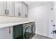 Modern laundry room with gray cabinets, long countertop, and Samsung washer/dryer at 2280 W 42Nd Ave, Denver, CO 80211
