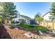 Spacious backyard with trampoline, patio, and wood chip area at 8762 Mourning Dove Ln, Highlands Ranch, CO 80126