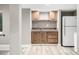 Basement kitchenette with wooden cabinetry, countertop, and a full-size refrigerator at 8762 Mourning Dove Ln, Highlands Ranch, CO 80126
