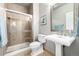 Bathroom with a glass-enclosed shower, pedestal sink, tiled flooring, and modern fixtures at 8762 Mourning Dove Ln, Highlands Ranch, CO 80126