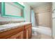 Well-lit bathroom with a double sink vanity, granite countertop, and a shower-tub combo at 8762 Mourning Dove Ln, Highlands Ranch, CO 80126