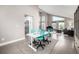 Open dining area with sleek table, bright blue chairs, and an open view into the living room at 8762 Mourning Dove Ln, Highlands Ranch, CO 80126