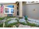 Inviting front yard with rock garden, blue planters, and brick accents at entry at 8762 Mourning Dove Ln, Highlands Ranch, CO 80126