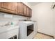 Functional laundry room featuring a utility sink, washer, dryer, and overhead cabinets at 8762 Mourning Dove Ln, Highlands Ranch, CO 80126