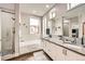 Bright bathroom features dual sinks, bathtub, glass enclosed shower, and modern finishes at 9636 Bennett Peak St, Littleton, CO 80125