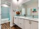 Bright bathroom with double vanity, modern fixtures, and tub-shower combo featuring stylish blue tiling at 9636 Bennett Peak St, Littleton, CO 80125